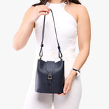 Night Owl | Model wearing leather bucket shoulder bag with adjustable strap and magnetic closure 