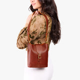 Nutmeg | Model wearing leather bucket shoulder bag with adjustable strap and magnetic closure 