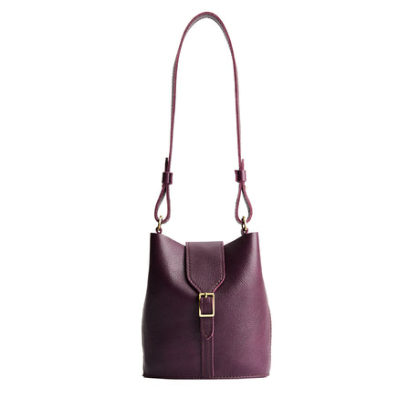 Plum | Leather bucket shoulder bag with adjustable strap and magnetic closure on a white background