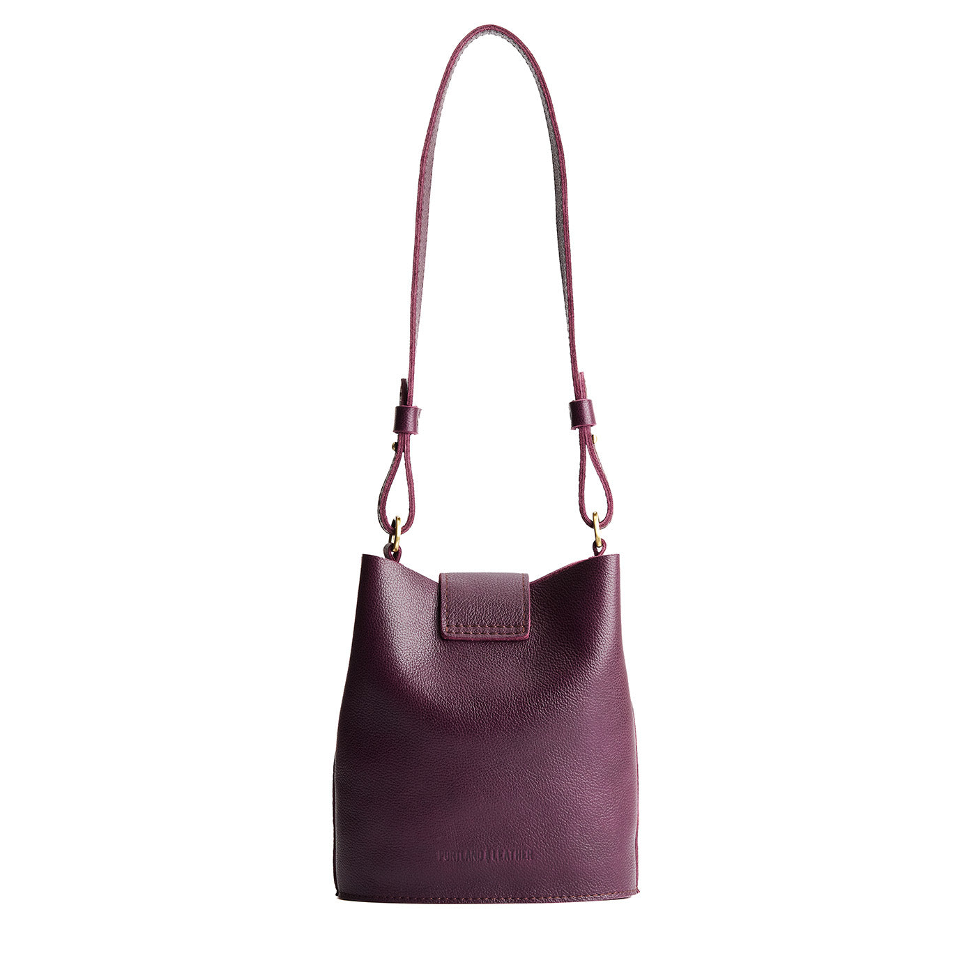 Plum | Leather bucket shoulder bag with adjustable strap and magnetic closure on a white background
