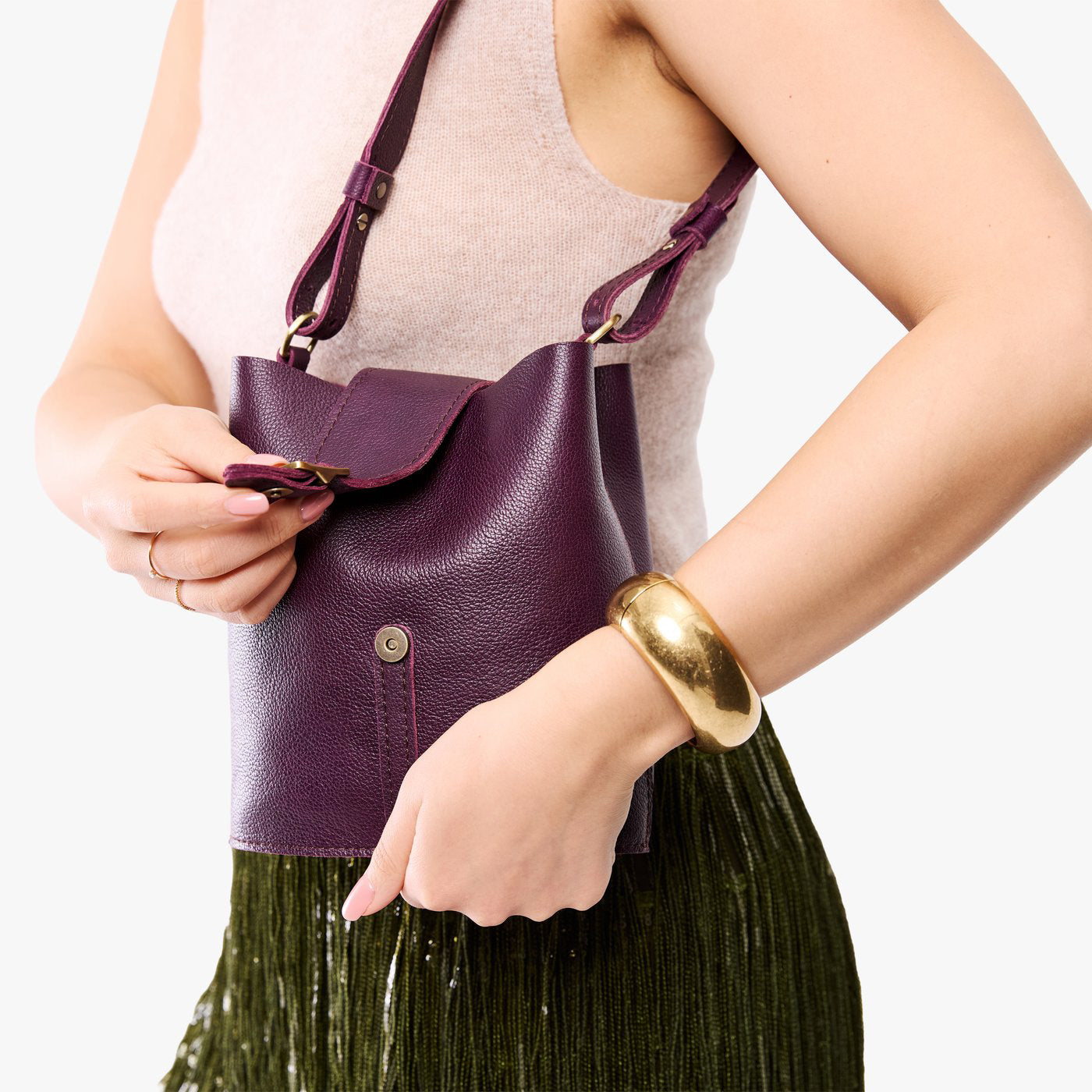 Plum | Model wearing leather bucket shoulder bag with adjustable strap and magnetic closure 