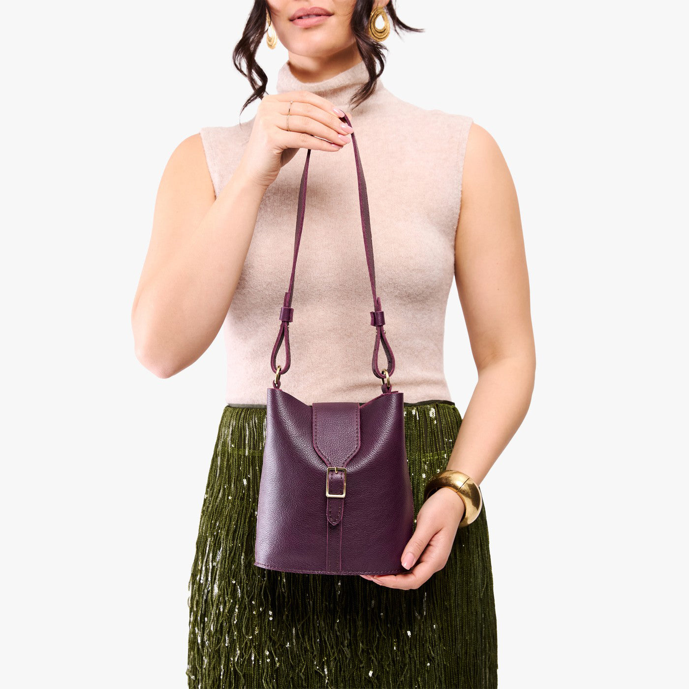Plum | Model wearing leather bucket shoulder bag with adjustable strap and magnetic closure 