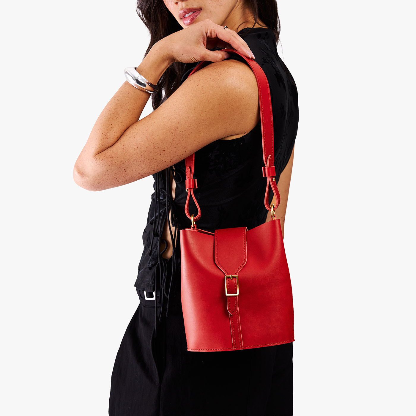 Ruby | Model wearing leather bucket shoulder bag with adjustable strap and magnetic closure