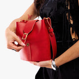 Ruby | Model wearing leather bucket shoulder bag with adjustable strap and magnetic closure 