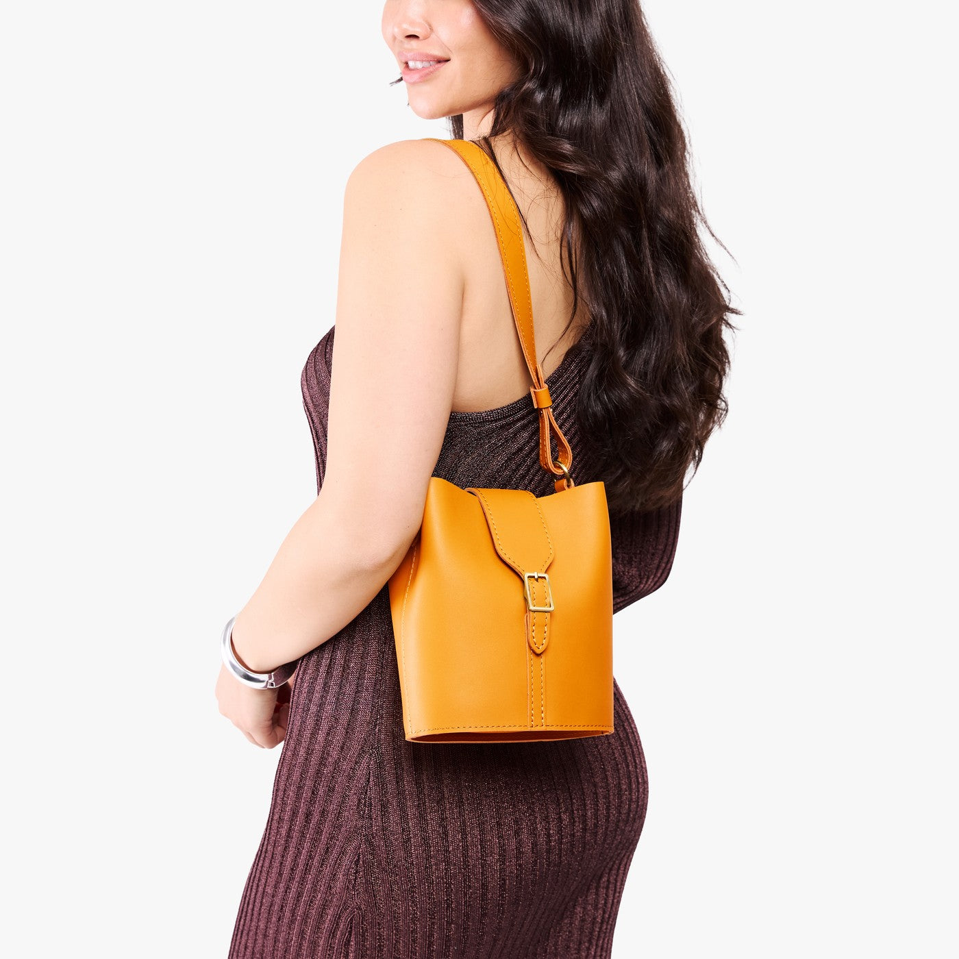 Sunflower | Model wearing leather bucket shoulder bag with adjustable strap and magnetic closure 
