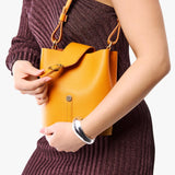 Sunflower | Model wearing leather bucket shoulder bag with adjustable strap and magnetic closure 