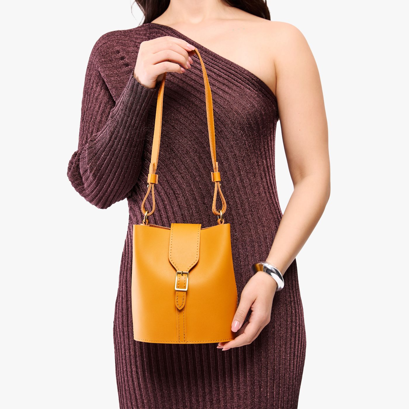 Sunflower | Model wearing leather bucket shoulder bag with adjustable strap and magnetic closure 