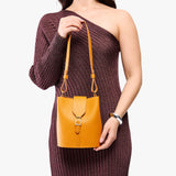 Sunflower | Model wearing leather bucket shoulder bag with adjustable strap and magnetic closure 