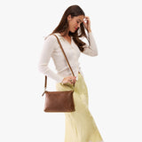 Asheville Large | Model wearing a zip top crossbody bag with detachable strap