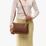 Asheville Large | Model holding a zip top crossbody bag with detachable strap