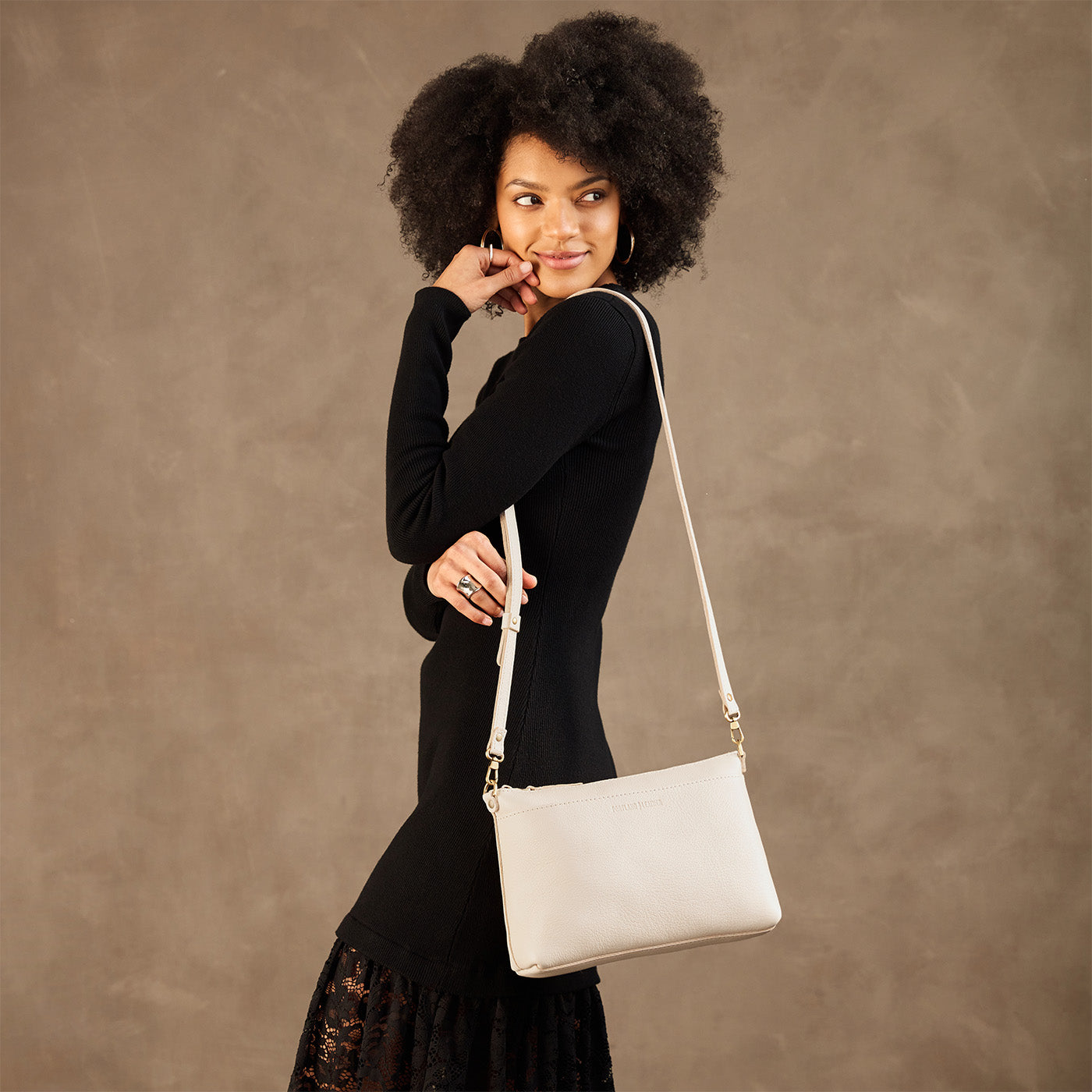 Pebbled Bone*Large | Model wearing a zip top crossbody bag with detachable strap 