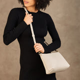 Pebbled Bone Large | Model wearing a zip top crossbody bag with detachable strap