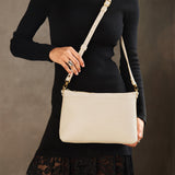 Pebbled Bone Large | Model wearing a zip top crossbody bag with detachable strap