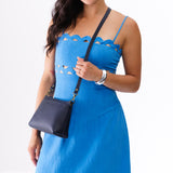 Night Owl Classic | A Model holding a zip top crossbody bag with detachable strap