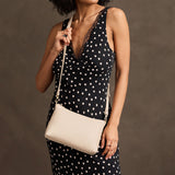 Pebbled Bone Classic | Model wearing a zip top petite crossbody bag with detachable strap