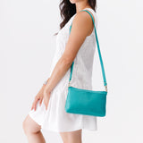 Seafoam Classic | Model holding a zip top crossbody bag with detachable strap