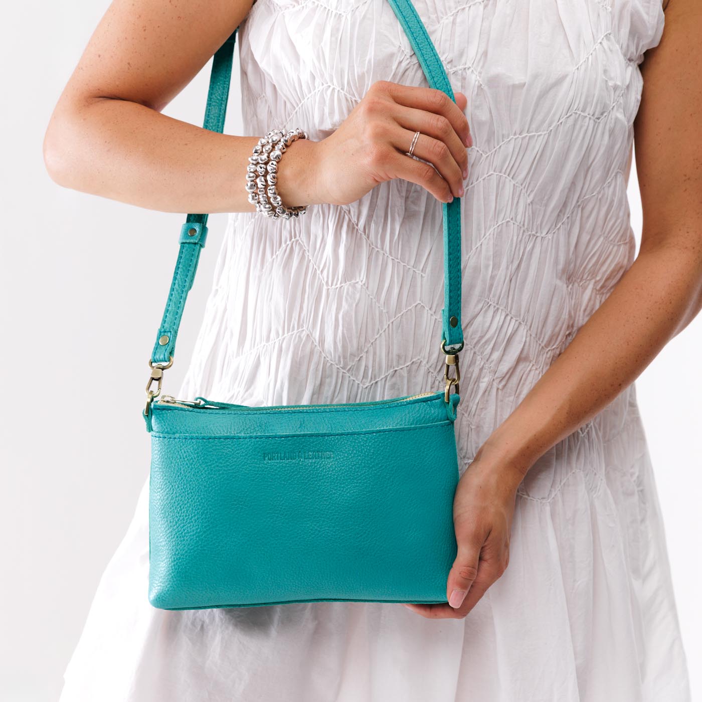 Seafoam*Classic | Model holding a zip top crossbody bag with detachable strap