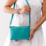 Seafoam Classic | Model holding a zip top crossbody bag with detachable strap