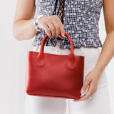 Ruby Small | Model holding petite tote purse with structured leather handles and crossbody strap
