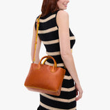 Sienna Large | Model wearing a mid-size tote purse with  structured leather handles and crossbody strap