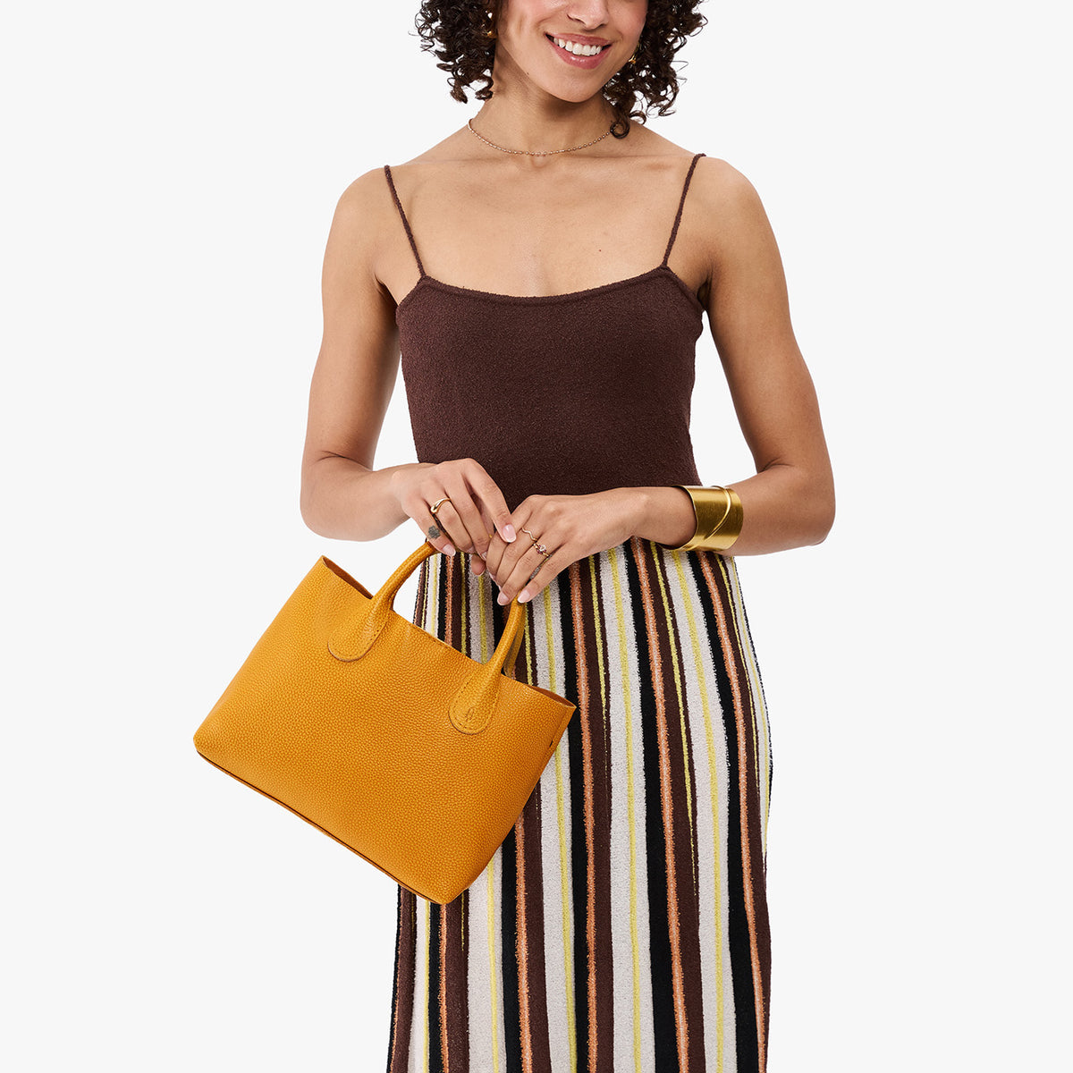 Sunshine*Large | Model wearing a mid-size tote purse with  structured leather handles and crossbody strap