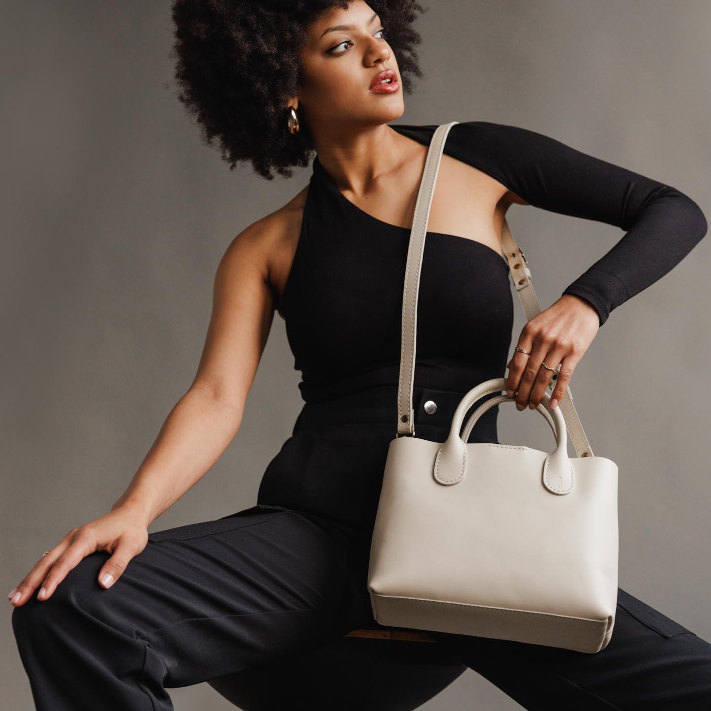 Bone*Large | Model holding mid-size tote purse with  structured leather handles and crossbody strap