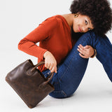 Coldbrew Large | Model holding mid-size tote purse with structured leather handles and crossbody strap