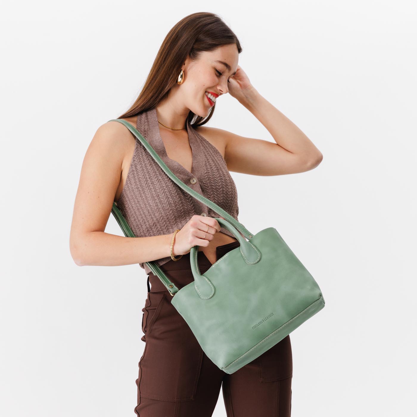 Cucumber*Large | Model holding mid-size tote purse with  structured leather handles and crossbody strap