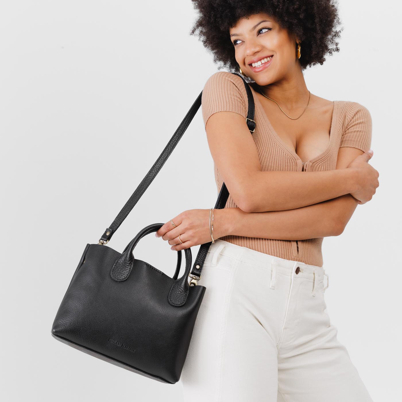 Pebbled--black*Large | Model holding mid-size tote purse with  structured leather handles and crossbody strap