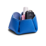 Skyway | Flower-shaped foldable leather tray with snap-button corners holding nail polish and car keys