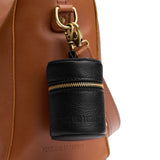 Pebbled--black | Cylindrical shaped pouch with a gold zipper and swivel lobster claw clasp on a bag