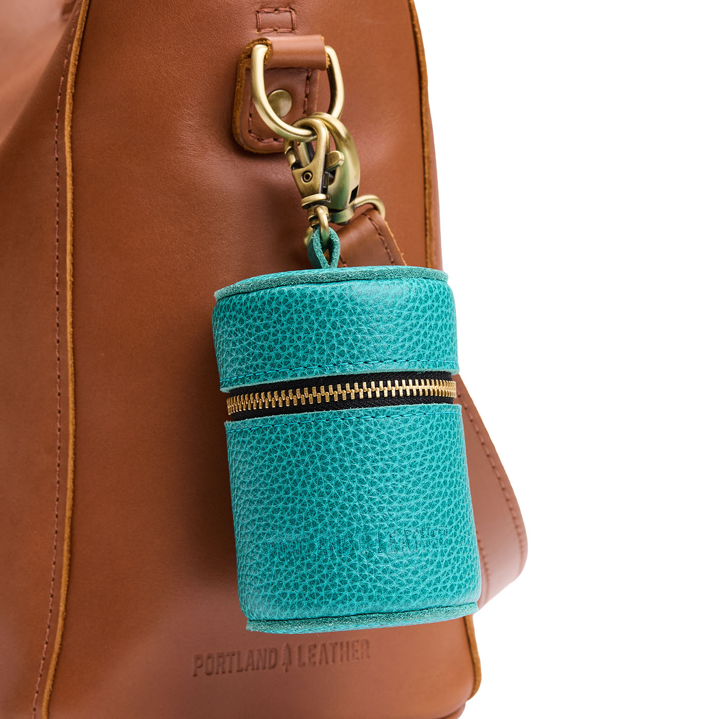 Seafoam | Cylindrical shaped pouch with a gold zipper and swivel lobster claw clasp on a bag