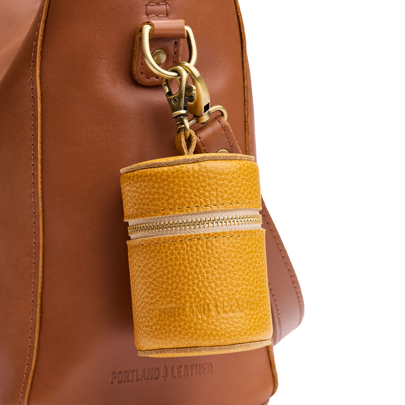 Sunshine | Cylindrical shaped pouch with a gold zipper and swivel lobster claw clasp on a bag