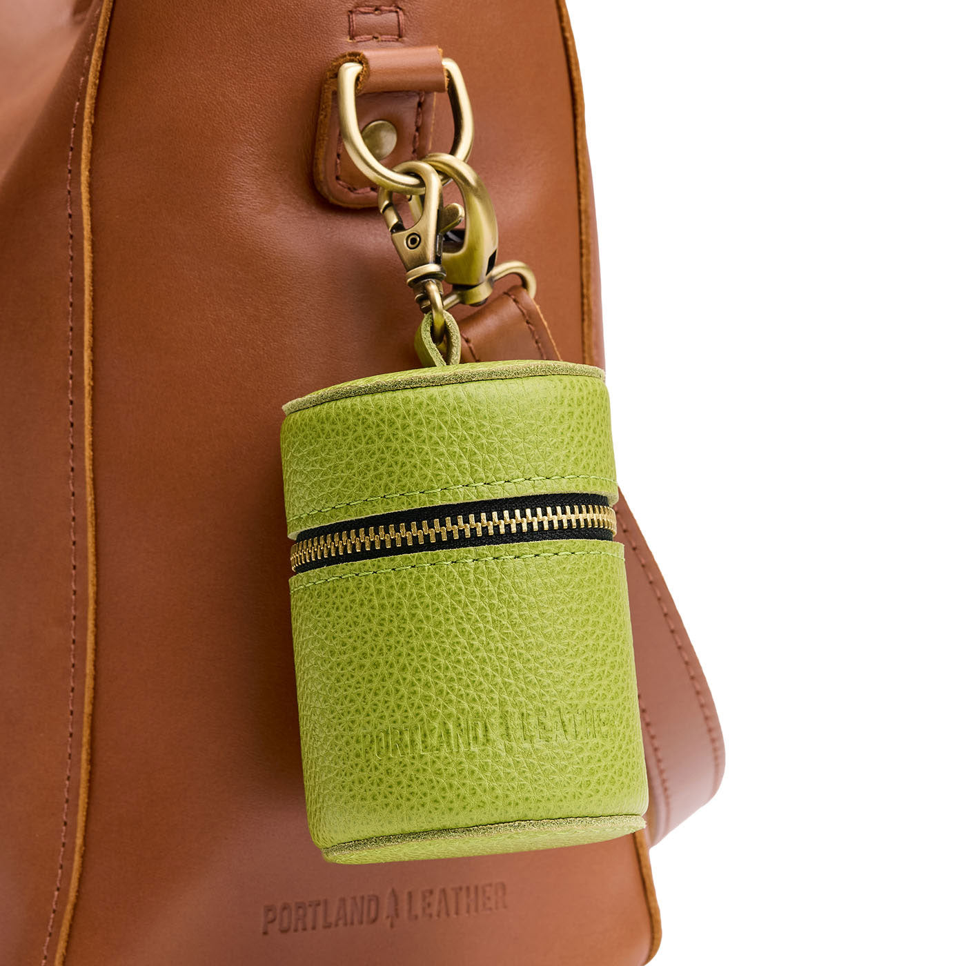 Wasabi | Cylindrical shaped pouch with a gold zipper and swivel lobster claw clasp on a bag