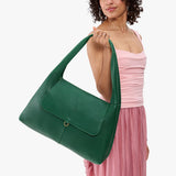 Bacalar Large | A model holding a slouchy triangle shaped shoulder bag with a flap