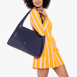Cobalt Large | A model holding a slouchy triangle shaped shoulder bag with a flap