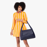 Cobalt Large | A model holding a slouchy triangle shaped shoulder bag with a flap