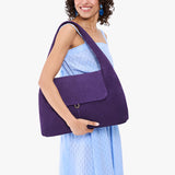 Imperial Large | A model holding a slouchy triangle shaped shoulder bag with a flap