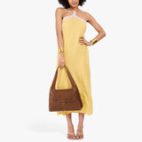 Asheville Medium | A model holding a slouchy triangle shaped shoulder bag with a flap
