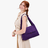 Imperial Medium | A model holding a slouchy triangle shaped shoulder bag with a flap