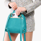 Seafoam | Model pulling smartphone out of back zipper pocket of a leather backpack