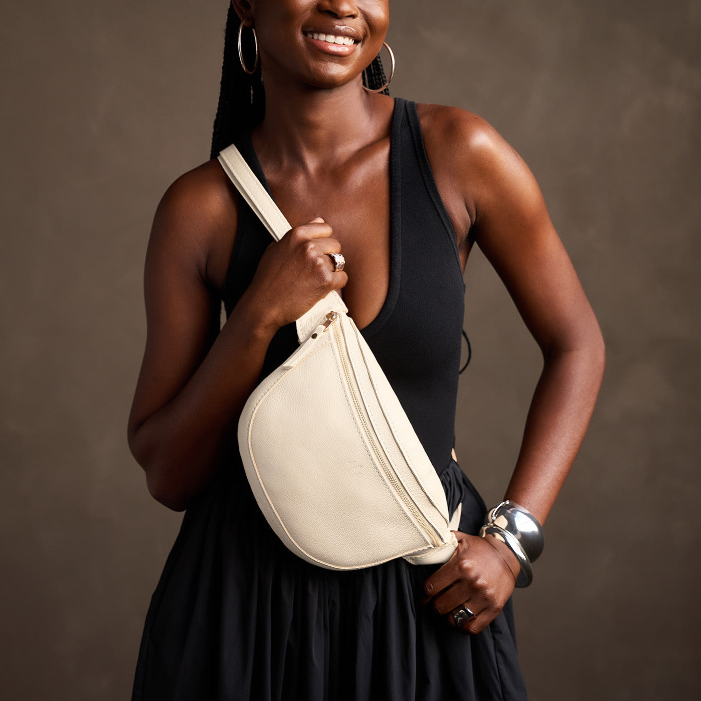 Pebbled Bone | Model wearing a sling bag with front zipper