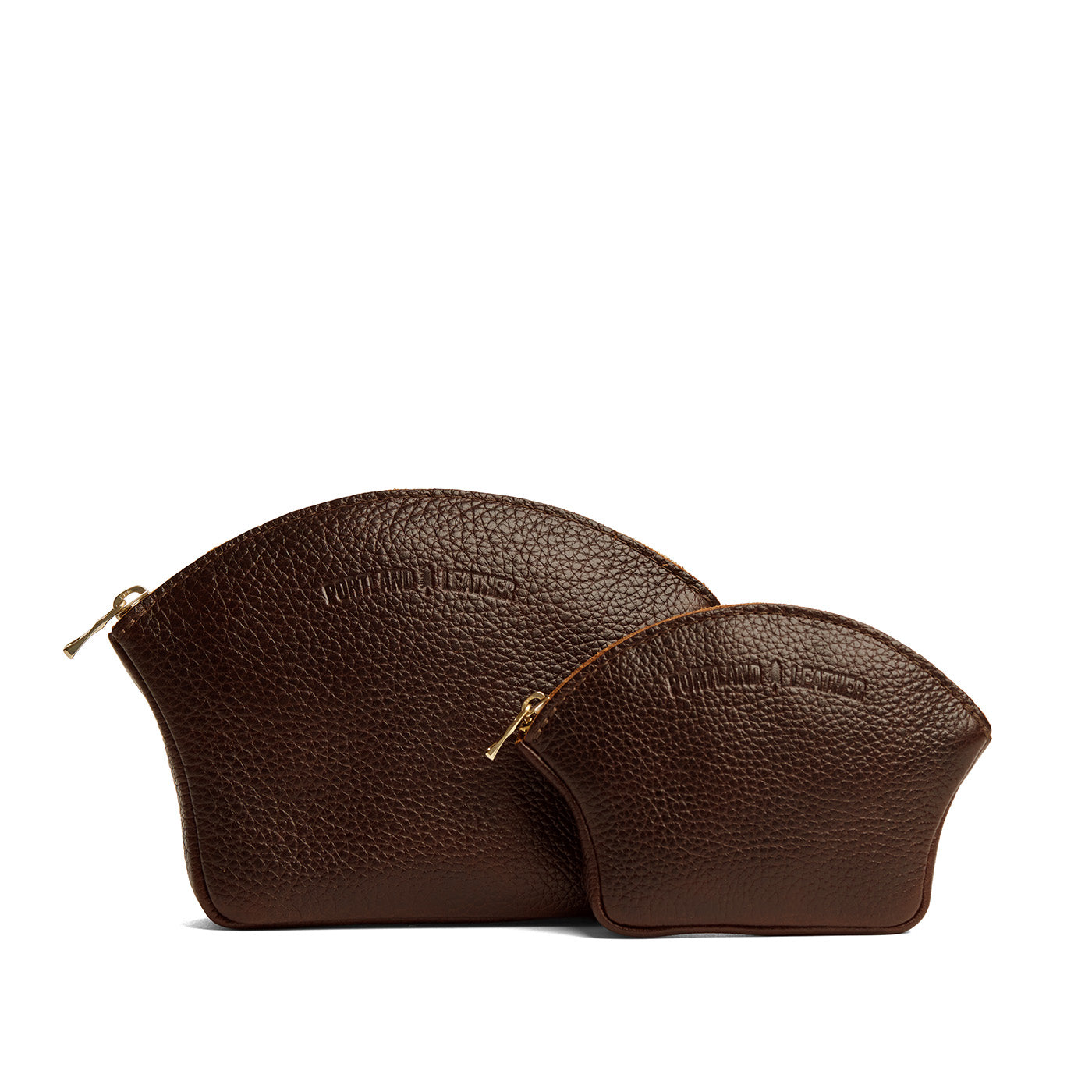 Coldbrew | Comparison shot of small and large seashell shaped leather makeup bags with curved top zipper and flat bottom