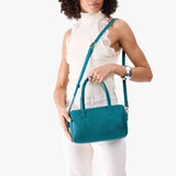 Aquarius Large | Model holding mini duffle shaped handbag with crossbody strap