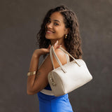Bone Large | Model wearing mini duffle shaped handbag with crossbody strap
