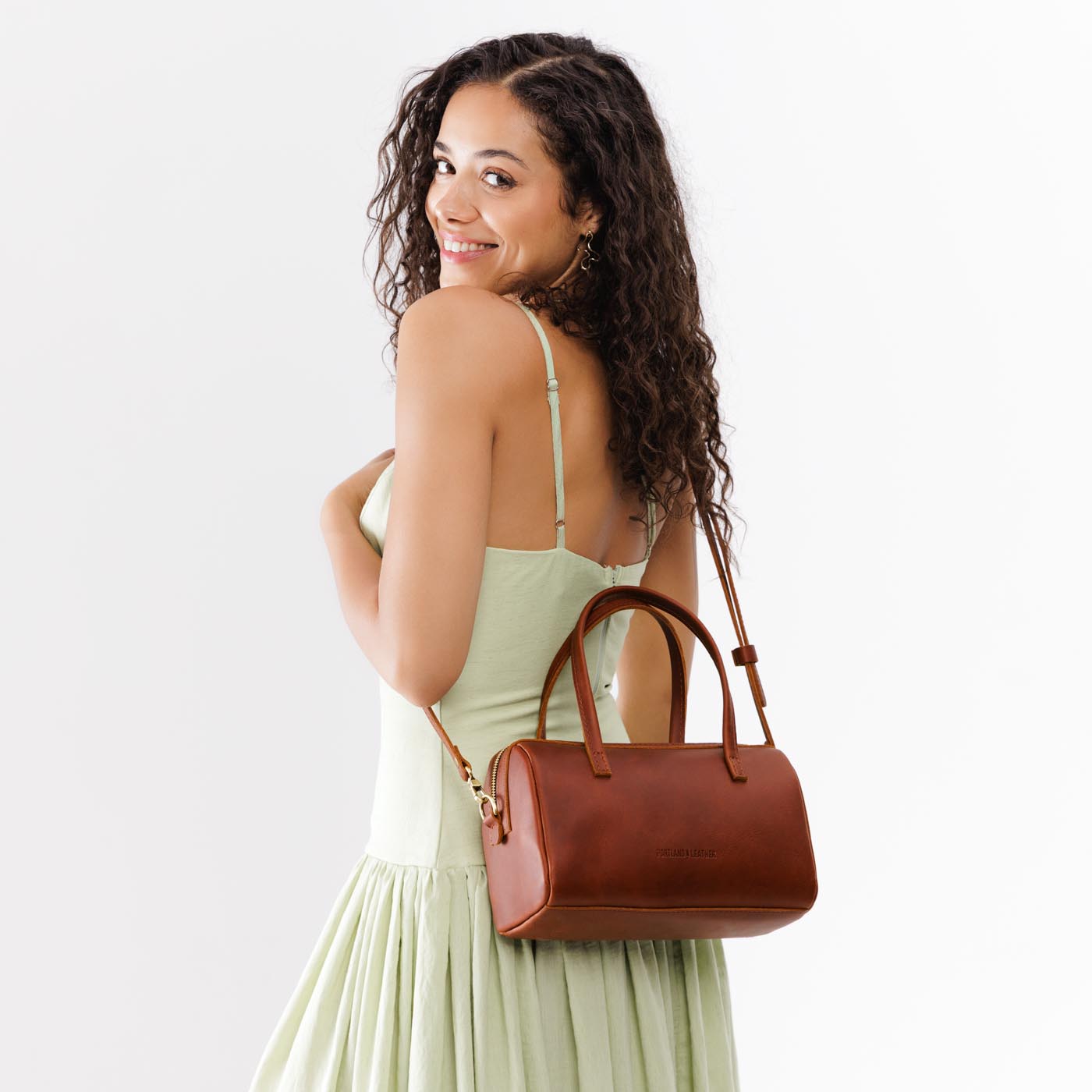 Chestnut*Large | Model wearing mini duffle shaped handbag with crossbody strap