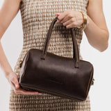 Coldbrew Large | Model wearing mini duffle shaped handbag with crossbody strap