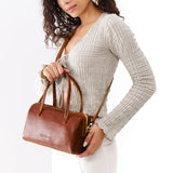 Nutmeg Large | Model wearing mini duffle shaped handbag with crossbody strap