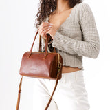 Nutmeg Large | Model wearing mini duffle shaped handbag with crossbody strap