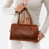Nutmeg Large | Model wearing mini duffle shaped handbag with crossbody strap